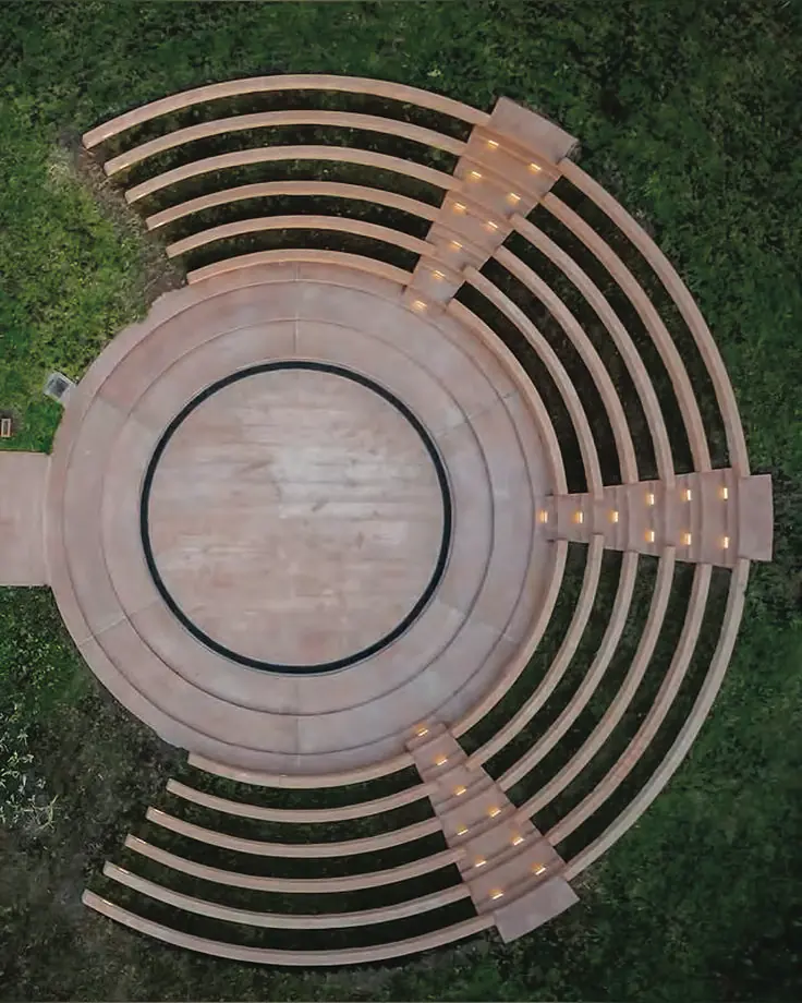 Top-down view of a circular stepped amphitheatre with timber seating
