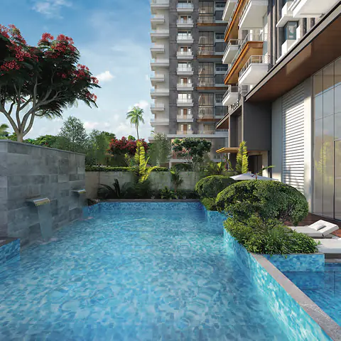 Pool deck with a stone water feature and flowering trees beside the tower